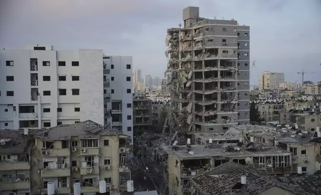 Israeli security forces inspect destroyed buildings that were hit by a missile fired from Iran, near Tel Aviv, Israel, Sunday, June 15, 2025. (AP Photo/Ohad Zwigenberg)