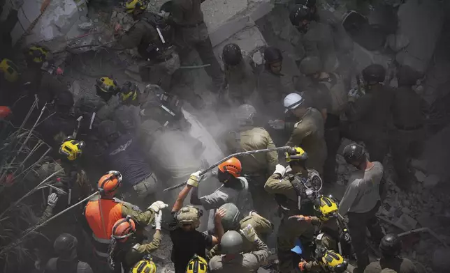 Israeli soldiers search for survivors amid the rubble of residential buildings destroyed by an Iranian missile strike in Bat Yam, central Israel, on Sunday, June 15, 2025. (AP Photo/Ariel Schalit)
