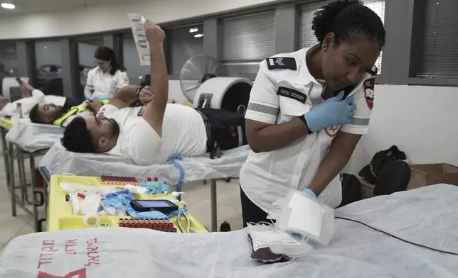 Medics with Israel's Magen David Adom emergency service donate blood to prepare for mass casualties in the event of strikes by Iran, in Jerusalem, Saturday, June 14, 2025. (AP Photo/Maya Alleruzzo)