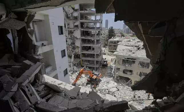 Israeli rescue team search for survivors amid the rubble of residential buildings destroyed by an Iranian missile strike in Bat Yam, central Israel, on Sunday, June 15, 2025. (AP Photo/Baz Ratner)