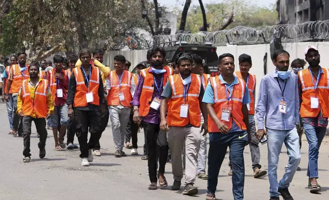 Workers come out from Thursday's Air India plane crash site in Ahmedabad, India, Sunday, June 15, 2025. (AP Photo/Ajit Solanki)