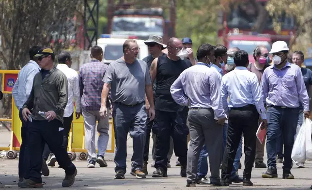 Investigators come out after visiting Thursday's Air India plane crash site in Ahmedabad, India, Sunday, June 15, 2025. (AP Photo/Ajit Solanki)