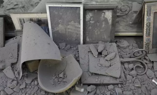 Dust covers framed family photos and personal objects at the site of a direct hit from an Iranian missile strike in Ramat Gan, Israel, Thursday, June 19, 2025. (AP Photo/Oded Balilty)