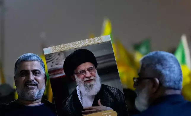 A protester holds a portrait of Iran's Supreme Leader Ayatollah Ali Khamenei during a protest against Israeli attacks on multiple cities across Iran, at a bridge leading to the fortified Green Zone where the U.S. Embassy is located in Baghdad, Iraq, Wednesday, June 18, 2025. (AP Photo/Hadi Mizban)