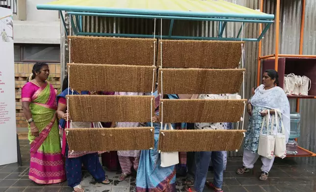 Daily wage workers, who mostly work outdoors, explore Neralu, an innovative portable heat shelter, at the Sweat and Concrete 2025 event in Bengaluru, India, Thursday, May 29, 2025. (AP Photo/Aijaz Rahi)