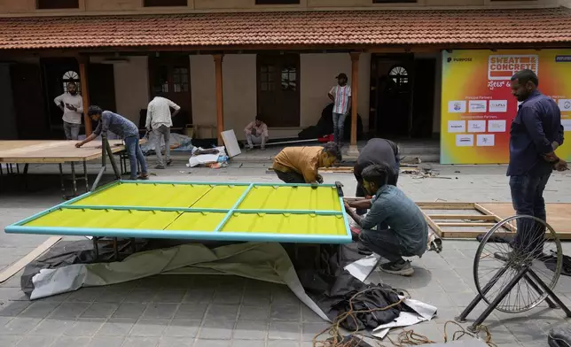 Workers assemble Neralu, an innovative portable heat shelter, before installing it at the Sweat and Concrete 2025 event in Bengaluru, India, Wednesday, May 28, 2025. (AP Photo/Aijaz Rahi)