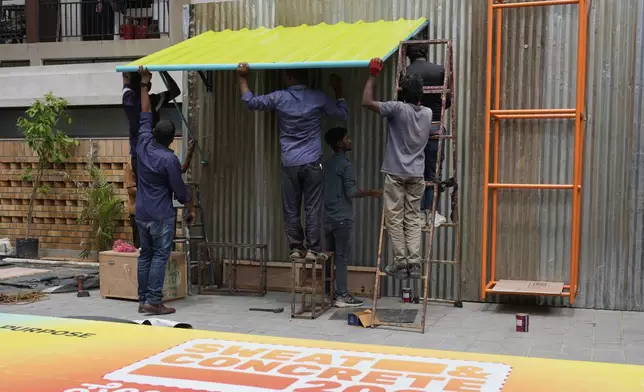 Workers install Neralu, an innovative portable heat shelter, ahead of the Sweat and Concrete 2025 event in Bengaluru, India, Wednesday, May 28, 2025. (AP Photo/Aijaz Rahi)