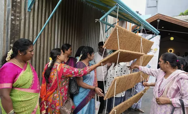 Daily wage workers, who mostly work outdoors, explore Neralu, an innovative portable heat shelter, at the Sweat and Concrete 2025 event in Bengaluru, India, Thursday, May 29, 2025. (AP Photo/Aijaz Rahi)
