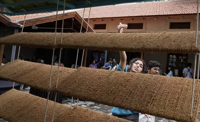 Ankritya Diggavi, one of the architects behind the design of Neralu, an innovative portable heat shelter, explains its features to visitors at the Sweat and Concrete 2025 event in Bengaluru, India, Thursday, May 29, 2025. (AP Photo/Aijaz Rahi)