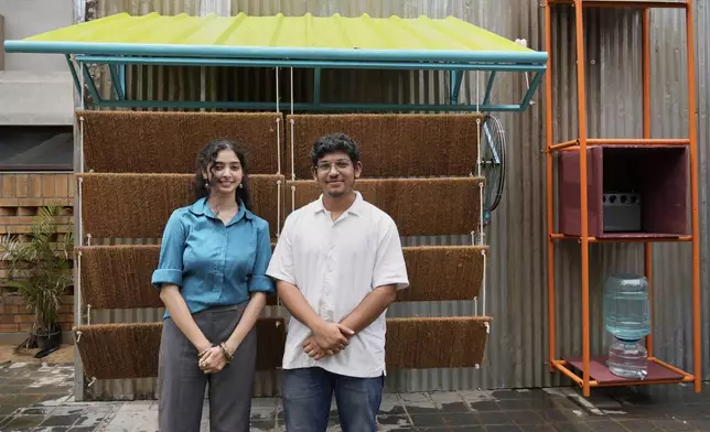 Ankritya Diggavi, left, and Sagar Kandal, architects behind the design of Neralu, an innovative portable heat shelter, pose in front of their installation at the Sweat and Concrete 2025 event in Bengaluru, India, Thursday, May 29, 2025. (AP Photo/Aijaz Rahi)