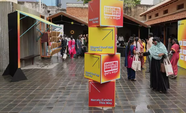 Daily wage workers, who mostly work outdoors, leave after exploring Neralu, an innovative portable heat shelter, at the Sweat and Concrete 2025 event in Bengaluru, India, Thursday, May 29, 2025. (AP Photo/Aijaz Rahi)