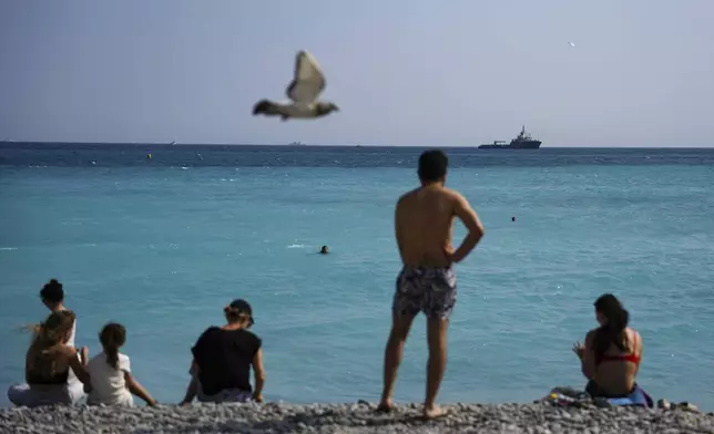 People wacth vessels sail during the "Ocean Wonders" event in honor of World Oceans Day ahead of the U.N. Ocean Conference on Sunday, June 8, 2025, in Nice, France. (AP Photo/Annika Hammerschlag)