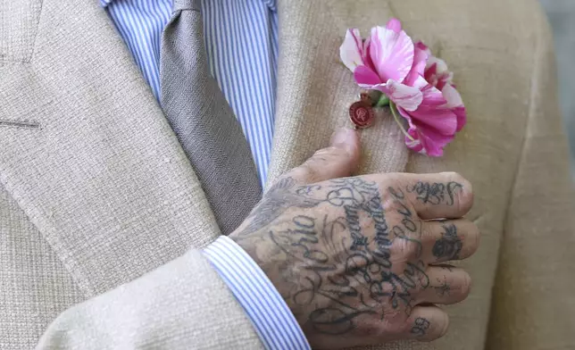 Former soccer player David Beckham adjusts a "King's Rose" by David Austin Roses, as he waits to meet Britain's King Charles and Queen Camilla, at the RHS Chelsea Flower Show in London, Britain, May 19, 2025. (Toby Melville/Pool Photo via AP)
