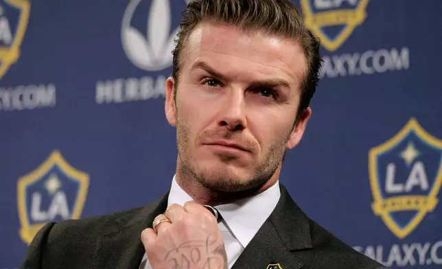 FILE - Los Angeles Galaxy's David Beckham fixes his tie during a news conference in Los Angeles, Jan. 19, 2012. (AP Photo/Jae C. Hong, File)