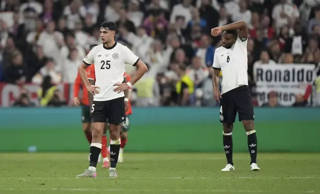 Germany's Jonathan Tah, right and Aleksandar Pavlovic are dejected after Portugal's Cristiano Ronaldo scored his side's second goal during the Nations League semifinal soccer match between Portugal and Germany at the Munich Football Arena, in Munich, Germany, Wednesday, June 4, 2025. (AP Photo/Matthias Schrader)
