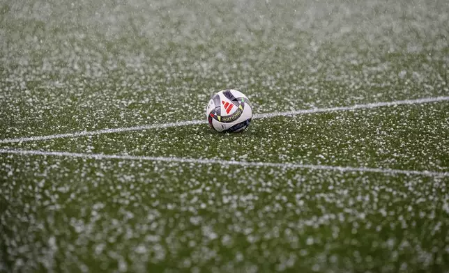 A football sits on the pitch during a hailstorm before the Nations League semifinal soccer match between Portugal and Germany at the Munich Football Arena, in Munich, Germany, Wednesday, June 4, 2025. (AP Photo/Martin Meissner)