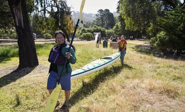 From left, Juan Bay, president of the Waorani people of Ecuador, and Isabella Zizi carry a kayak to the beach before entering the San Francisco Bay, Thursday, June 19, 2025, in Richmond, Calif. (AP Photo/Godofredo A. Vásquez)