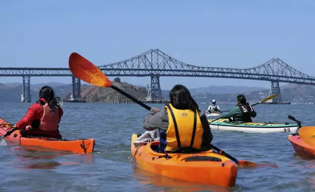 A delegation of Indigenous leaders from Ecuador kayak in the San Francisco Bay to take a closer look at the Chevron Long Wharf, Thursday, June 19, 2025, in Richmond, Calif. (AP Photo/Godofredo A. Vásquez)