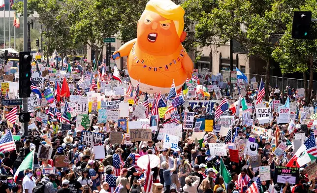 EDS NOTE: OBSCENITY - Demonstrators march in the "No Kings" protest with a President Donald Trump balloon in Los Angeles on Saturday, June 14, 2025. (AP Photo/Noah Berger)