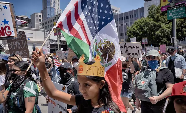 A young protester carries a combination Mexican and U.S. flag during a "No Kings" protest in downtown Los Angeles on Saturday, June 14, 2025. (AP Photo/Richard Vogel)