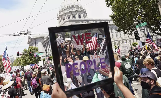 Rachel Podolsky holds a mirror as she marches towards City Hall during the "No Kings Day" protest in San Francisco on Saturday, June 14, 2025. (Scott Strazzante/San Francisco Chronicle via AP)