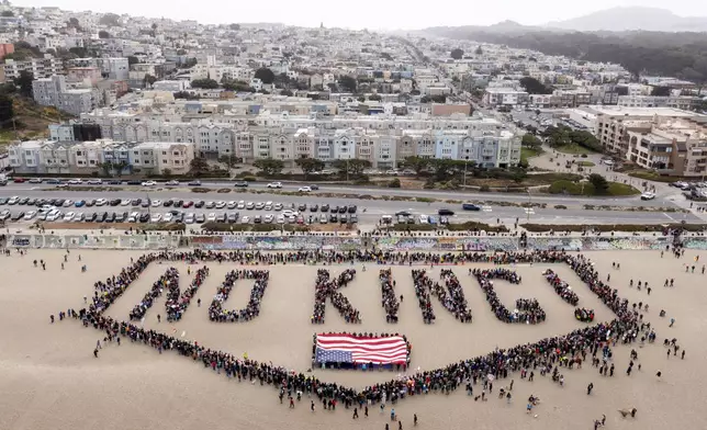 People form a human banner at Ocean Beach during the "No Kings" protests in San Francisco on Saturday, June 14, 2025. (Santiago Mejia/San Francisco Chronicle via AP)