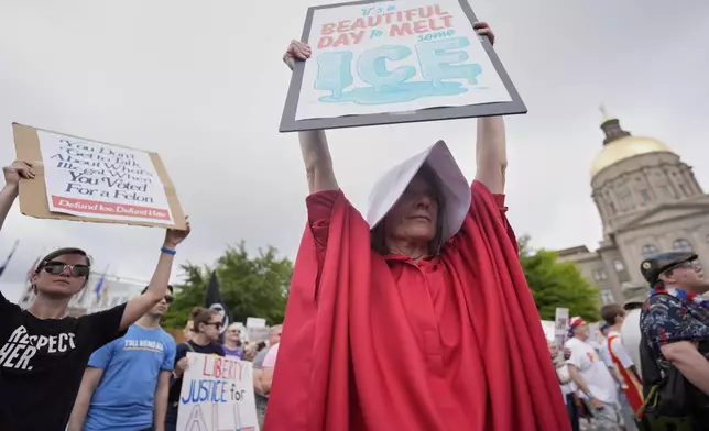 A demonstrator holds a sign during a "No Kings" protest, Saturday, June 14, 2025, in Atlanta. (AP Photo/Mike Stewart)