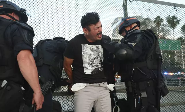 California Highway Patrol officers arrest a man after a dispersal order during a protest Saturday, June 14, 2025, in Los Angeles. (AP Photo/Ethan Swope)