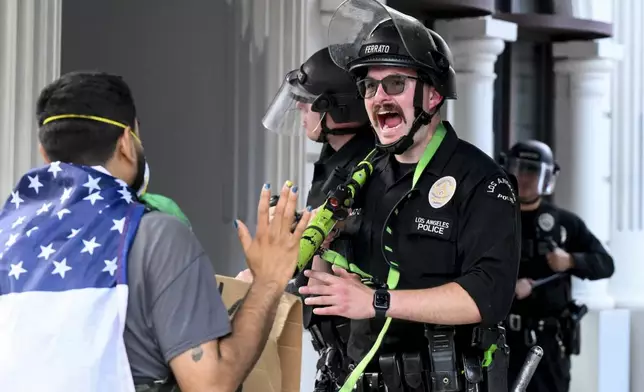 A Los Angeles police officer shouts at a demonstrator during a protest Saturday, June 14, 2025, in Los Angeles. (AP Photo/Noah Berger)