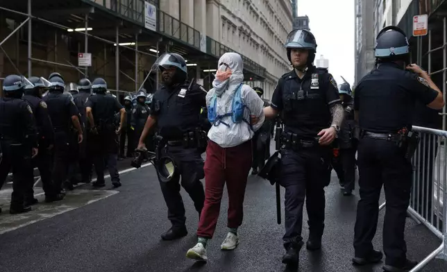 New York Police officers escort a protestor after making an arrest during a protest outside a federal building, Saturday, June 14, 2025, in New York. (AP Photo/Stefan Jeremiah)