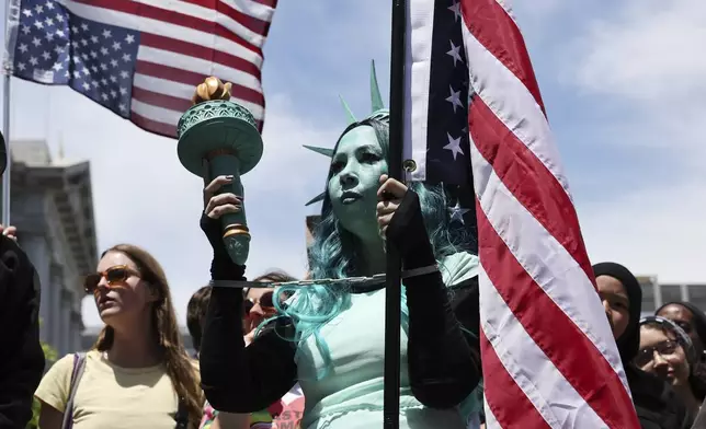 Lola Hottensen is costumed as Lady Liberty as she attends a protest on Saturday, June 14, 2025, in San Francisco. (AP Photo/Benjamin Fanjoy)