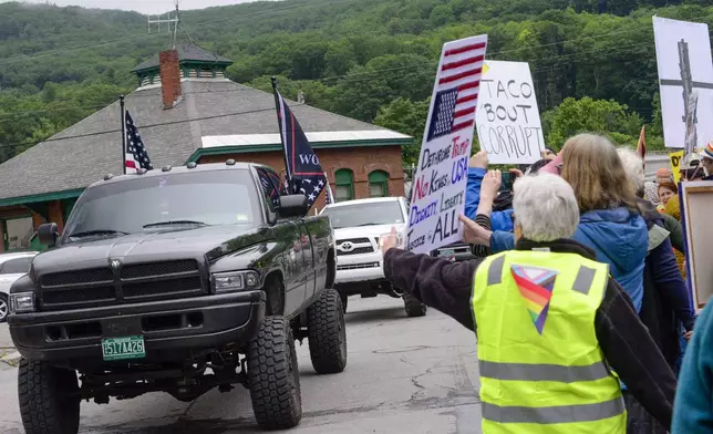 A small group of Trump supporters drives peacefully through as several hundred gathered outside of the train station in Bellows Falls, Vt., to show support for the third annual Pride Whistle-Stop Tour, that also encompassed people participating in the "No Kings" protest, Saturday, June 14, 2025, as the Amtrak Vermonter travels from St. Albans south to Brattleboro. (Kristopher Radder/The Brattleboro Reformer via AP)