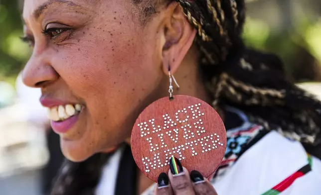 Lisha Bell shows off her earrings during festivities at the Oakland Museum to celebrate Juneteenth in Oakland, Calif., on Thursday, June 19, 2025.(Gabrielle Lurie/San Francisco Chronicle via AP)