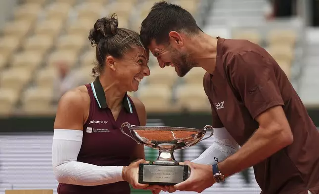 Winners Italy's Sara Errani and Andrea Vavassori celebrate with the trophy after the mixed doubles final match of the French Tennis Open against Taylor Townsend and Evan King of the U.S. at the Roland-Garros stadium in Paris, Thursday, June 5, 2025. (AP Photo/Aurelien Morissard)