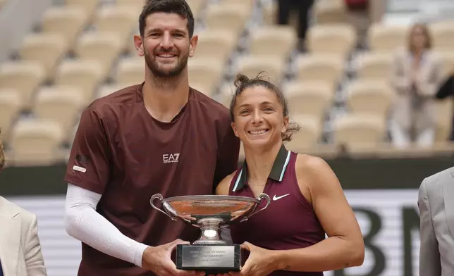 Winners Italy's Sara Errani and Andrea Vavassori pose with the trophy after the mixed doubles final match of the French Tennis Open against Taylor Townsend and Evan King of the U.S. at the Roland-Garros stadium in Paris, Thursday, June 5, 2025. (AP Photo/Aurelien Morissard)