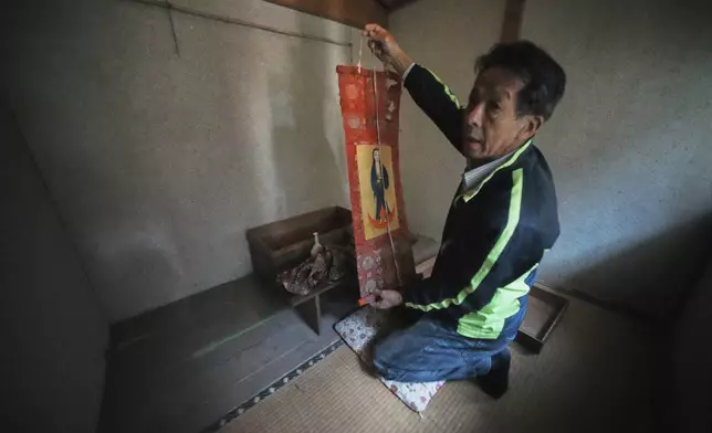 Masatsugu Tanimoto, a farmer and one of the few remaining hidden Christians on Ikitsuki Island, prepares a scroll of the Virgin Mary and Jesus once secretly worshipped at his home in Ikitsuki Island in Hirado, southern Japan, Sunday, April 27, 2025. (AP Photo/Eugene Hoshiko)