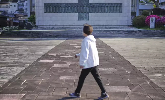 A woman walks past the Twenty-Six Martyrs Monument in Nagasaki, southern Japan, on Saturday, April 26, 2025, which commemorates 26 Christians executed in 1597. (AP Photo/Eugene Hoshiko)