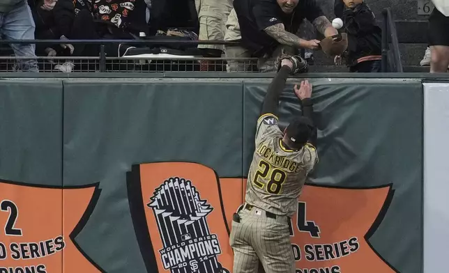 San Diego Padres left fielder Brandon Lockridge (28) is unable to catch a two-run home run hit by San Francisco Giants' Matt Chapman during the sixth inning of a baseball game Wednesday, June 4, 2025, in San Francisco. (AP Photo/Godofredo A. Vásquez)