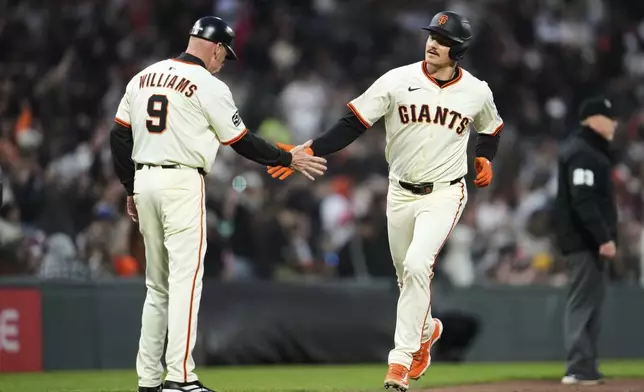 San Francisco Giants' Matt Chapman, right, celebrate with third base coach Matt Williams (9) after hitting a two-run home run during the sixth inning of a baseball game against the San Diego Padres, Wednesday, June 4, 2025, in San Francisco. (AP Photo/Godofredo A. Vásquez)