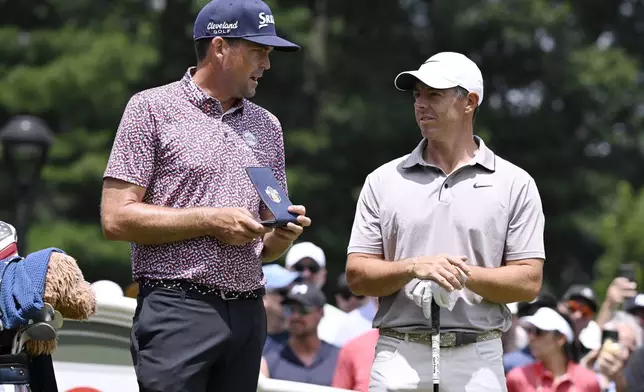 Keegan Bradley, left, talks with Rory McIlroy, right, of Northern Ireland, as they start the second round second round of the Travelers Championship golf tournament at TPC River Highlands, Friday, June 20, 2025, in Cromwell, Conn. (AP Photo/Jessica Hill)