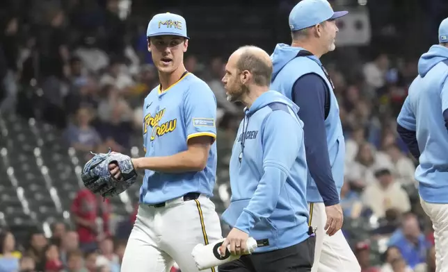 Milwaukee Brewers pitcher Jacob Misiorowski, left, walks off the field with head athletic trainer Brad Epstein, second from left, during the sixth inning of a baseball game against the St. Louis Cardinals, Thursday, June 12, 2025, in Milwaukee. (AP Photo/Kayla Wolf)