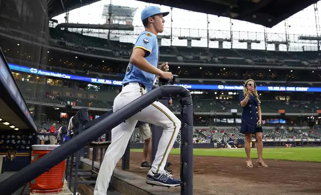 Milwaukee Brewers pitcher Jacob Misiorowski, center, runs onto the field to warm up for his major league debut in a baseball game against the St. Louis Cardinals, Thursday, June 12, 2025, in Milwaukee. (AP Photo/Kayla Wolf)