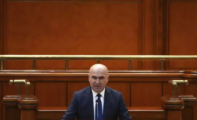 Romanian Prime Minister designate Ilie Bolojan addresses a joint parliament session ahead of a vote of confidence for the new government team in Bucharest, Romania, Monday, June 23, 2025. (AP Photo/Andreea Alexandru)