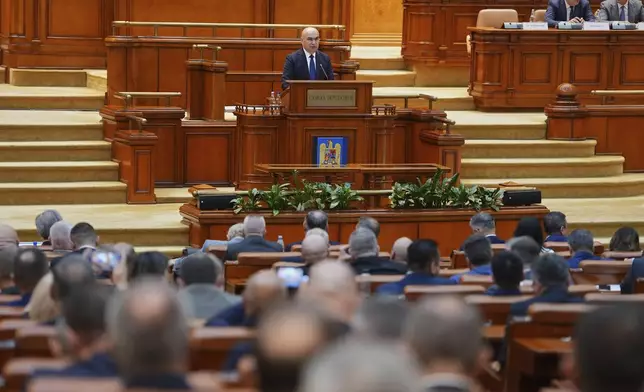 Romanian Prime Minister designate Ilie Bolojan addresses a joint parliament session ahead of a vote of confidence for the new government team in Bucharest, Romania, Monday, June 23, 2025. (AP Photo/Andreea Alexandru)