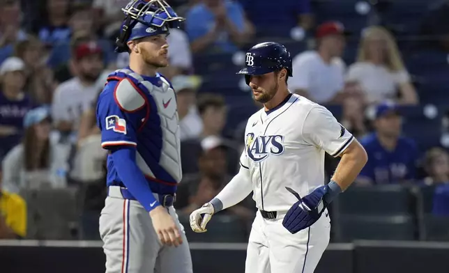 Tampa Bay Rays' Josh Lowe, right, scores in front of Texas Rangers catcher Jonah Heim (28) on an RBI double by Brandon Lowe during the third inning of a baseball game Wednesday, June 4, 2025, in Tampa, Fla. (AP Photo/Chris O'Meara)
