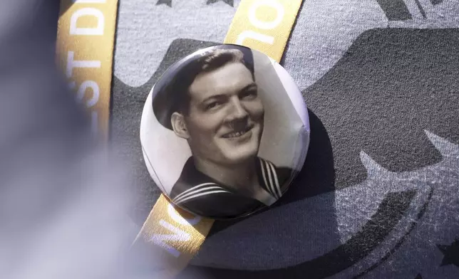 A black and white photo that Kara Houser, the granddaughter of a World War II veteran, pinned to her chest during a visit on Monday, June 2, 2025 in Colleville-sur-Mer, to the Normandy American Cemetery shows Fred Mitchell Shafer, who Houser said served aboard one of the landing craft that deposited American soldiers on Omaha Beach during the June 6, 1944, D-Day invasion of Nazi-occupied France (AP Photo/John Leicester)