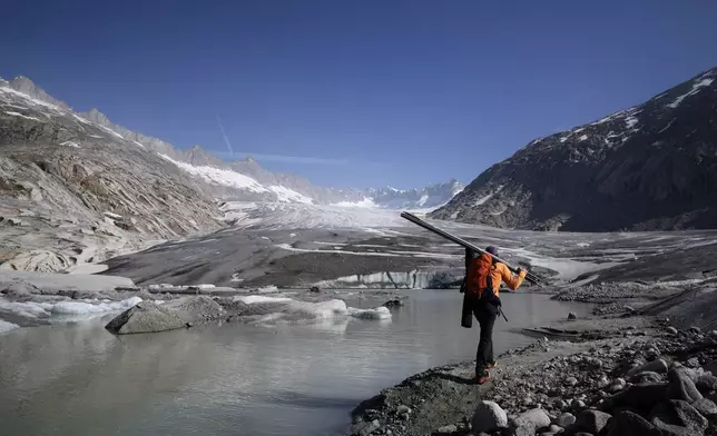 Matthias Huss, of the Federal Institute of Technology in Zurich and glacier monitoring group GLAMOS, arrives at the Rhone Glacier near Goms, Switzerland, June 10, 2025. (AP Photo/Matthias Schrader)
