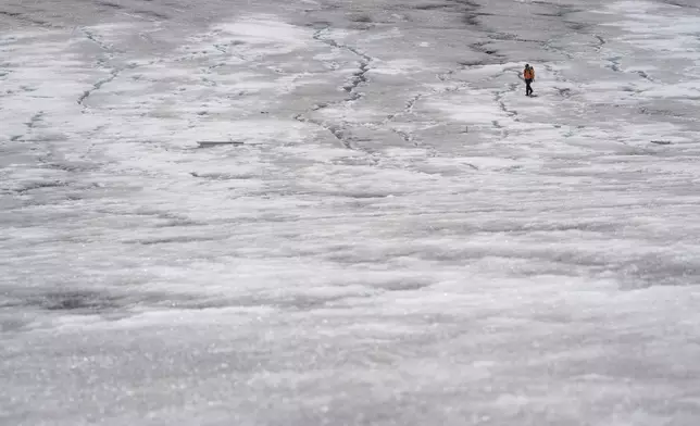 Matthias Huss, of the Federal Institute of Technology in Zurich and glacier monitoring group GLAMOS, arrives at the Rhone Glacier near Goms, Switzerland, June 10, 2025. (AP Photo/Matthias Schrader)