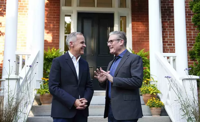 Prime Minister Mark Carney greets British Prime Minister Kier Starmer, outside his residence at Rideau Cottage in Ottawa, on Saturday, June 14, 2025, for a visit before the G7 Summit. (Justin Tang/The Canadian Press via AP)
