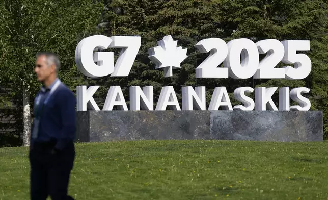 A man walks past a G7 sign outside the media centre for the G7 Summit on Sunday, June 15, 2025 in Banff, Alberta. (Adrian Wyld/The Canadian Press via AP)